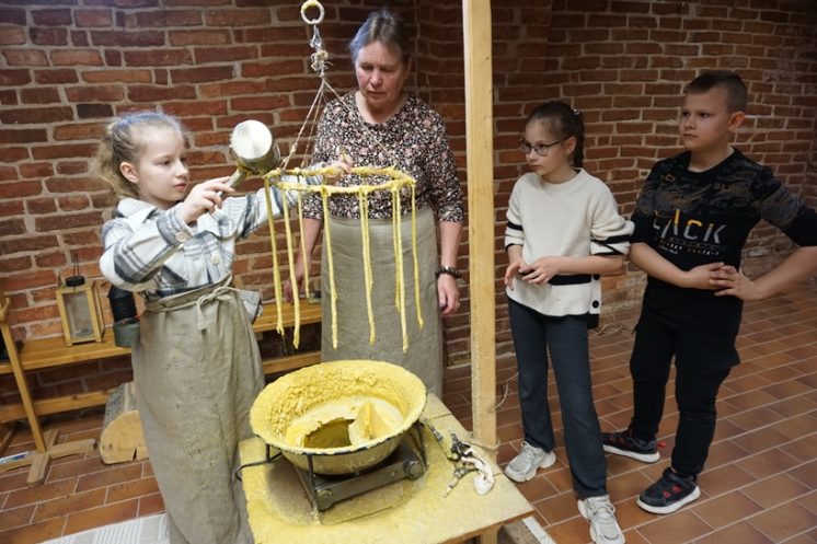 Vaikai su edukatore lieja žvakes