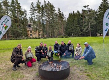 žmonių grupė prie laužo