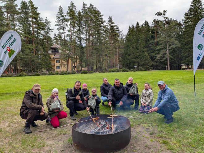 žmonių grupė prie laužo