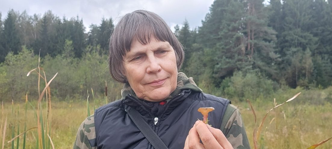 Moteris laiko grybą rankoje